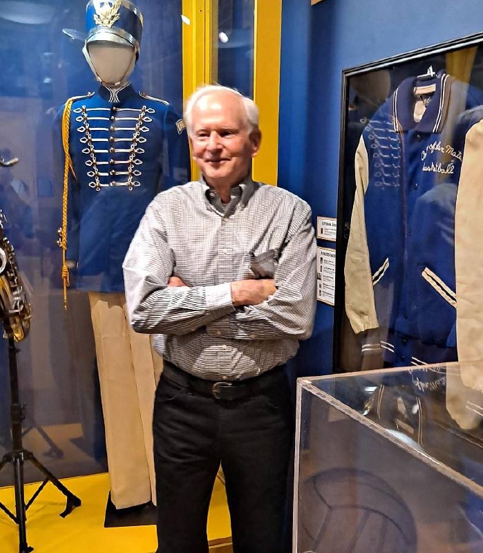 CSM alumni and former employee Gary Dilley standing next to his letterman jacket he received during his second year playing basketball as a student at CSM, long before he came to work at CSM as the dean of physical education and athletics until 2006
