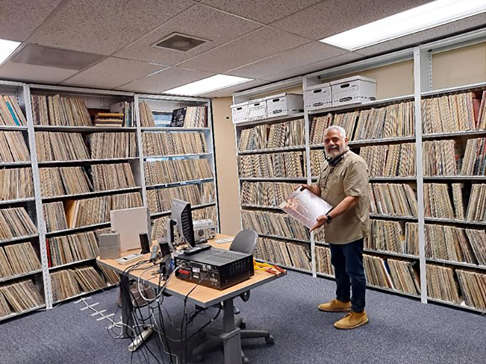 Current KCSM-FM general manager Dante Betteo shows off the station’s music library