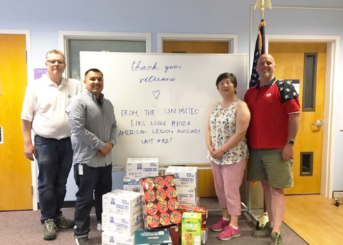 VROC program services coordinator Luis Padilla, second from left, with donors and their gifts to the center, including the whiteboard whose un-erased message helped send Army veteran Tina Wong to Stanford. Pictured with Padilla, from left: Tom Dasher, Peggy Toye and Brian Decker of the San Mateo Elks.